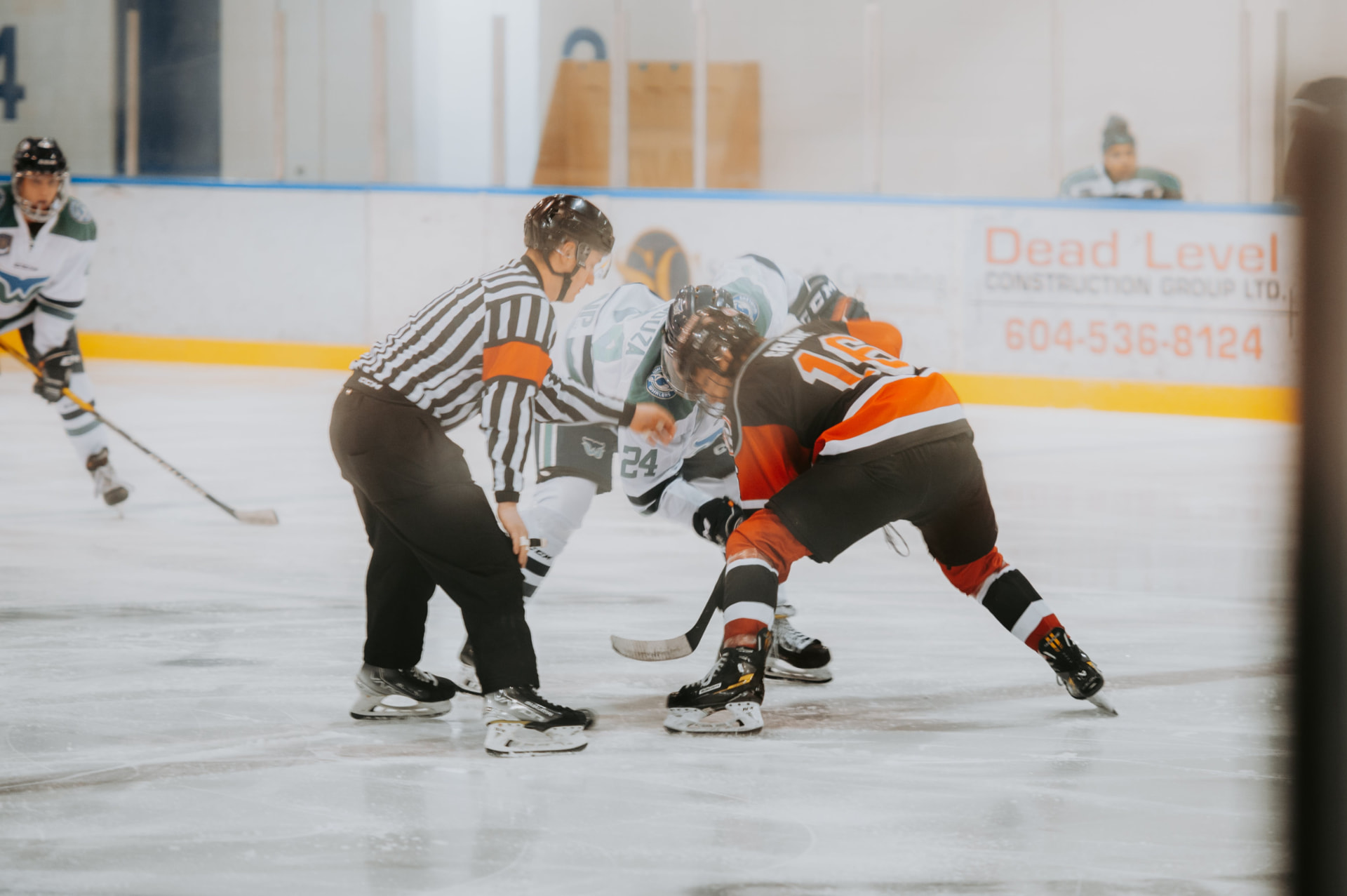 Two hockey players battling for the puck at a faceoff
